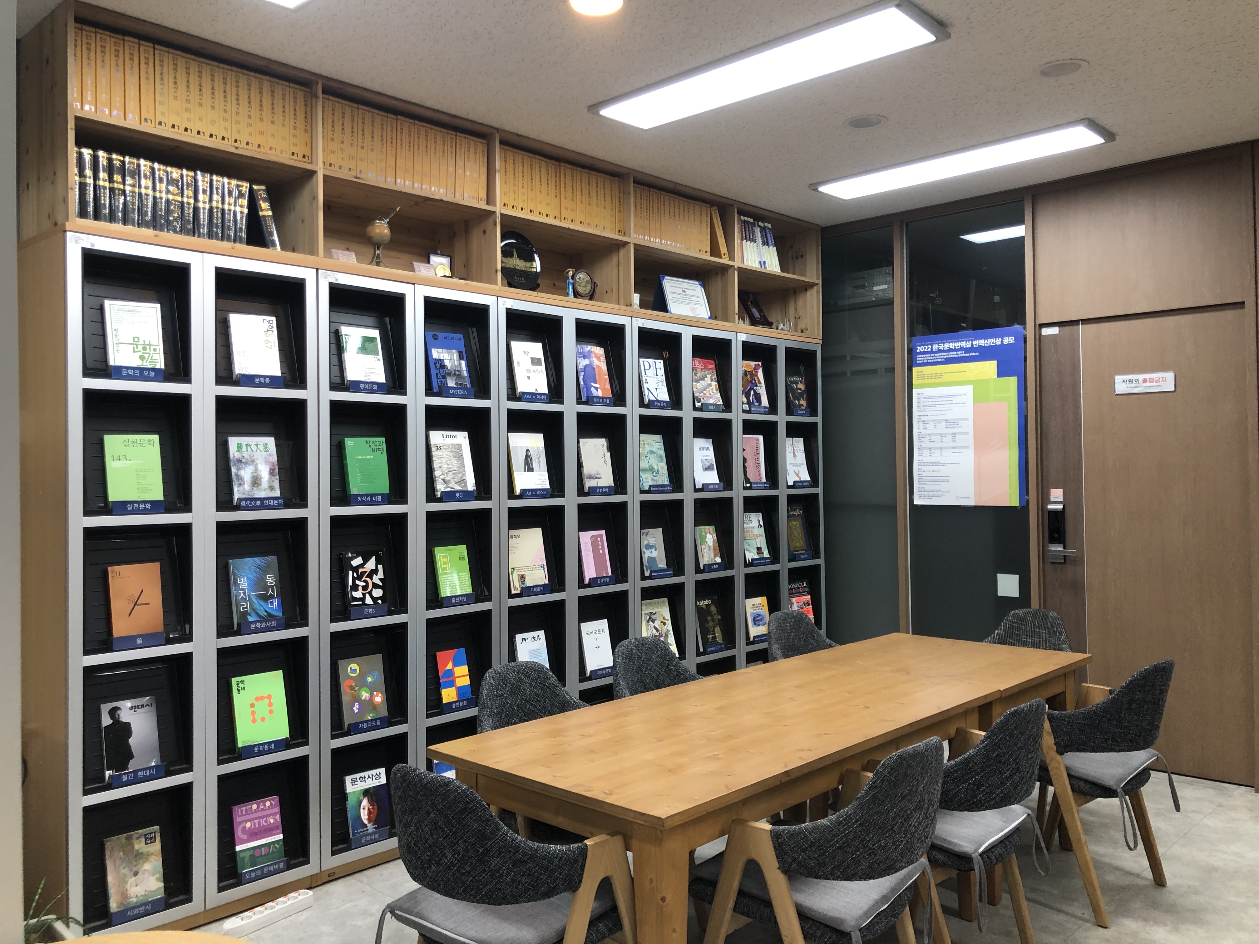 A library room with bookshelves filled with books and a wooden table with chairs.